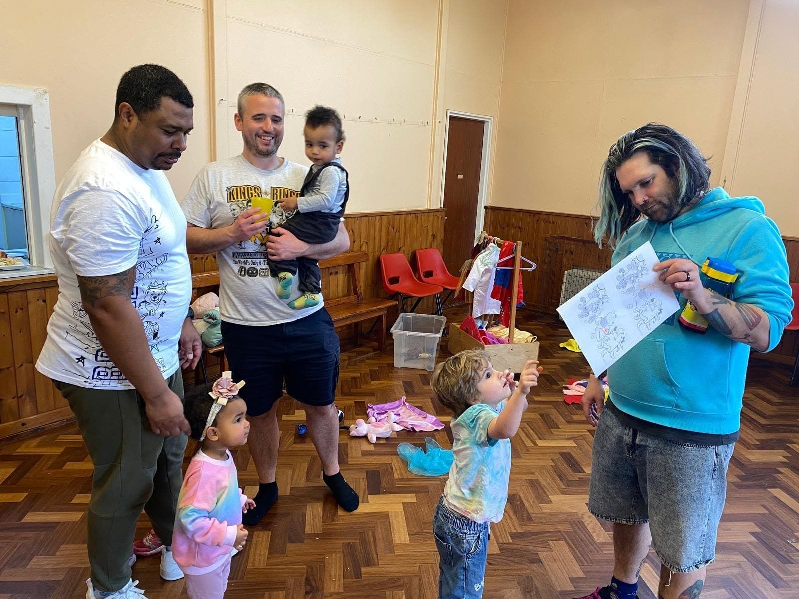Dads and young children taking part in an indoor group activity